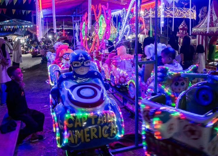 Sejumlah anak menikmati permainan di wahana permainan saat berwisata lebaran di Pasar Malam di Palu, Sulawesi Tengah, Minggu (14/4/2024). Sebagian warga di wilayah itu lebih memilih berwisata lebaran di Pasar Malam karena selain biayanya relatif lebih murah, juga menyediakan wahana permainan yang beragam. bmzIMAGES/Basri Marzuki