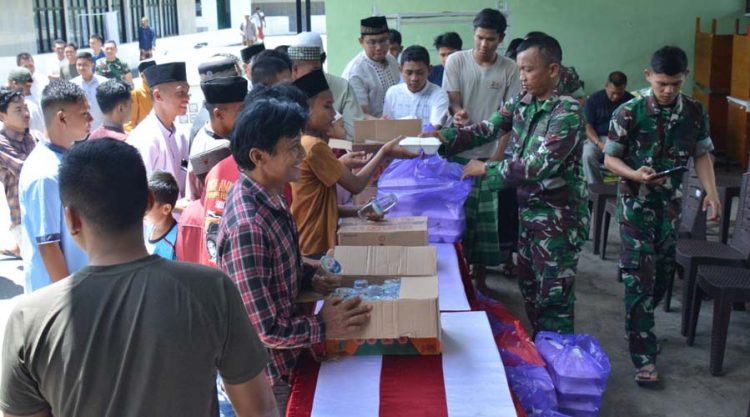 Petugas membagikan makanan kepada warga pada kegiatan Juamt Berkah di Makorem 132 Tadulako, Jumat (12/4/2024). (Foto: Penrem 132/Tdl)