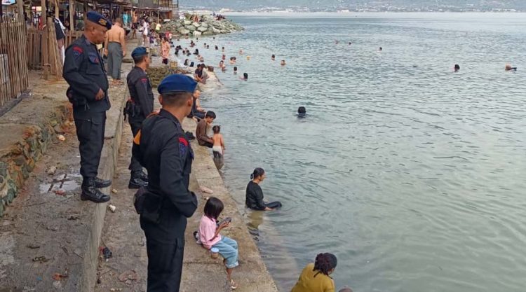 Tim SAR Satgas Operasi Ketupat TInombala memantau warga yang sedang mandi di pantai Kampung Nelayan Palu, Sabtu (13/4/2024). (Foto: Humas Ops Ketupat TInombala)