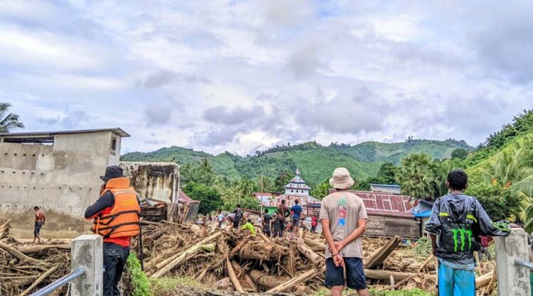 Warga berada di tumpukan kayu pasca banjir bandang di Desa Sibaloga, Kecamatan Tioribulu, Parigi Moutong, MInggu (23/6/2024). (Foto: HO-Basarnas Palu)