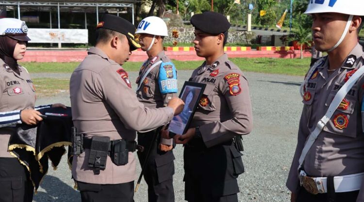 Kapolres Buol AKBP Handri Wira Suriyana (kedua kiri) mencoret foto anggota Polwan yang diberhentikan tidak dengan hormat di mapolres Buol, Senin (8/7/2024). (Foto: Humas Polres Buol)