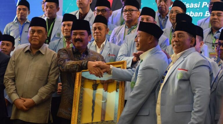 Menko Polhukam Hadi Tjahjanto menyerahkan piagam pengahrgaan kepada Ketua BKPRMI Kota Palu, Daud Usroh atas dedikasi dan pengabdian pada BKPRMI pada Munas XIV BPRKMI di Medan, SUmut, Kamis (8/8/2024). (Foto: Imron)