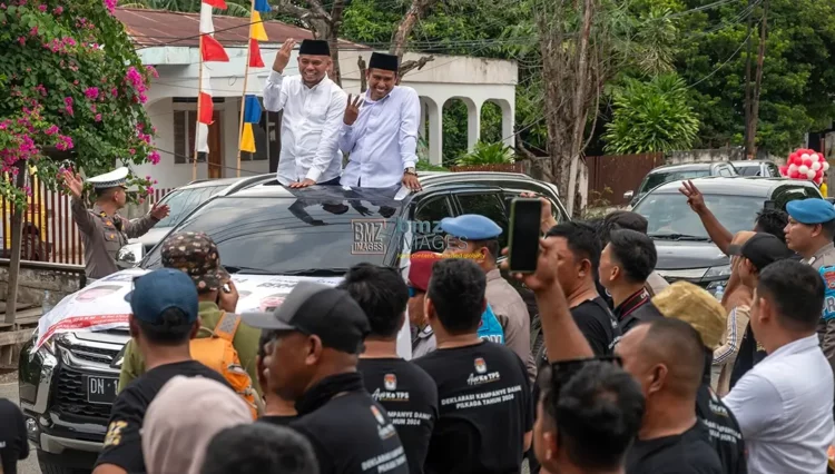 Paslon nomor urut 3 Muhammad J Wartabone (kiri) dan Rizal (kanan) mengangkat tiga jarinya pada konvoi kampanye damai di Palu, Selasa (24/9/2024). (Foto: bmzIMAGES/Basri Marzuki)