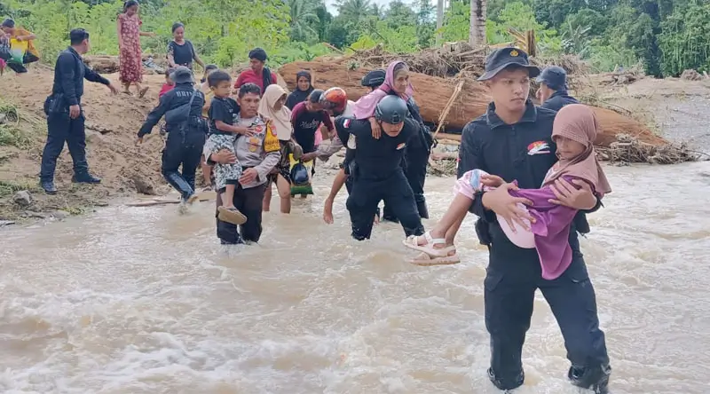 Personel Brimob Podla Sulteng mengevakuasi warga yang terperangkap banjri di Basidondo, Tolitoli, Minggu (2/2/2015). (Foto: Humas Polda Sutleng)