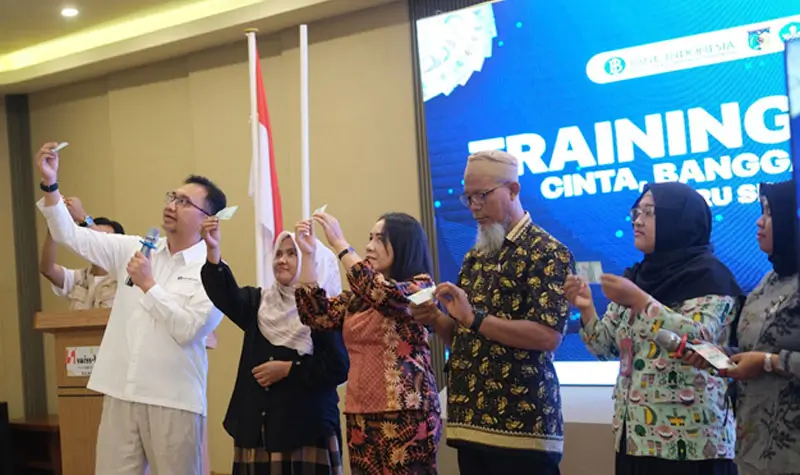 Kepala Perwakilan BI SUlteng, Rony Hartawan (kiri) mendemonstrasikan cara mengenali keaslian uang Rupiah pada Training of Trainers kepada guru di Palu, Jumat (16/5/2025). (Foto: Humas BI Sulteng)