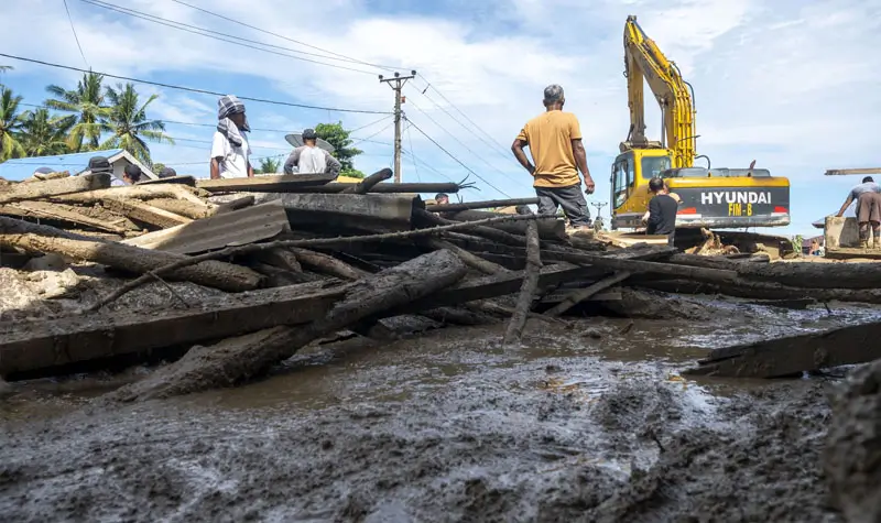 Alat berat bantuan BWSS dikerahkan untuk membersihakn lumpur yang menutup badan jalan pascabanjri bandang di Desa Wombo, Donggala, Rabu (28/5/2025). (Foto: bmzIMAGES/Basri Marzuki)