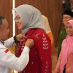 Wali Kota Palu, Hadianto Rasyid memasangkan pin pada Ketua DPD Lasqi Kota Palu, Diah Puspita usai pelantikan di Auditorium Wali Kota, Rabu (28/5/2025). (Foto: Prokopim Setda Kota Palu/Jufri)