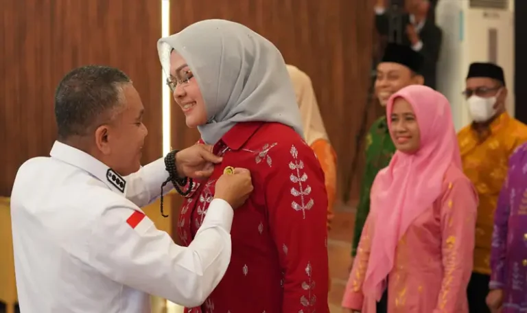 Wali Kota Palu, Hadianto Rasyid memasangkan pin pada Ketua DPD Lasqi Kota Palu, Diah Puspita usai pelantikan di Auditorium Wali Kota, Rabu (28/5/2025). (Foto: Prokopim Setda Kota Palu/Jufri)