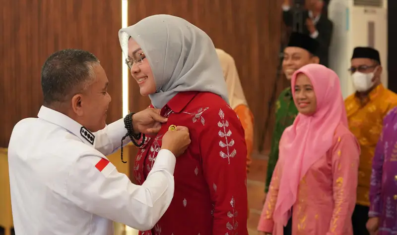 Wali Kota Palu, Hadianto Rasyid memasangkan pin pada Ketua DPD Lasqi Kota Palu, Diah Puspita usai pelantikan di Auditorium Wali Kota, Rabu (28/5/2025). (Foto: Prokopim Setda Kota Palu/Jufri)