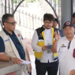 Kepala Pelaksana BPBD Kota Palu, Presly Tampubolon (kiri) mendampingi delegasi dari Kedutaan Swiss meninjau Huntap Talise, Rabu (14/5/2025). (Foto: Prokopim Setda Kota Palu/Iwan)