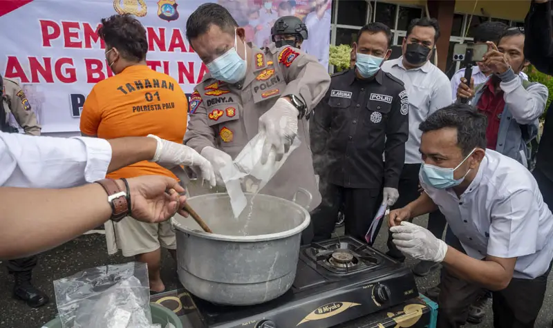 Kapolresta Palu, Kombes Pol Deny Abrahams (tengah menuang sabu ke dalam panci pada pemusnahan barang bukti sabu di Mapolreta Palu, Rabu (21/5/2025). (Foto: bmzIMAGES/bmz)