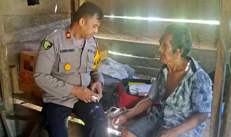 Kapolsek Ulubongka, Iptu Muhajir Wonti melayani warga yang memeriksa kesehatan di pelosok Desa Kasiala, Kecamatan Ulubongka, Kabupaten Tojo Unauna, Minggu (4/5/2025). (Foto: Humas Polresta Tojo Unauna)