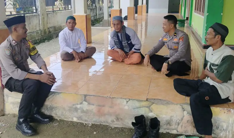 Ali Sarang berbincang dengan dengan Kanit Binmas Polsek Poso Pesisir, Ipda Ramlin, bersama Bhabinkamtibmas Desa Masani, pada Jumat siang (9/5/2025). (Foto: Humas Madago Raya)