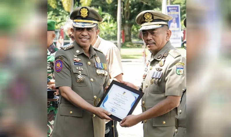 Gubernur Sulteng, Anwar Hafid (kiri) menyerahkan piagam penghargaan kepada Kasat Pol PP Kota Palu, Nathan Pagasongan pada Apel Kesiapsiagaan di parigi Moutong, Kamis (15/5/2025). (Foto: Satpol PP Kota Palu)