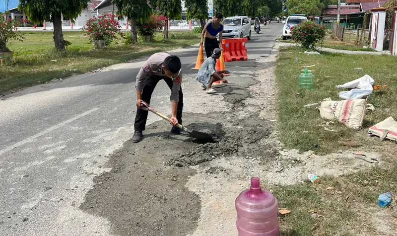 Personel Satlantas Polres Sigi menambal jalan untuk mencegah terjadinya kecelakaan lalu lintas di di Jalan Habib Muhammad Aljufri, Desa Kotapulu, Kecamatan Dolo, Kabupaten Sigi, Jumat (16/5/2025). (Foto: Huams Polres Sigi)