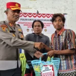 Kepala SPN Polda Sulteng, AKBP Seminar Sebayang menyerahkan bantuan kepada warga dalam kegiatan sosial di labuan Panimba, DOnggala , Selasa (3/6/2025). (Fot: Humas Polda Sulteng)