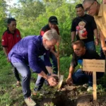 Country Director GIZ Indonesia, Hans Ludwig Bruns menanam pohon cendana menandai dimulainya pembangunan Arboretum di Taman Hutan Raya (Tahura) Kapopo, Senin (9/6/2025). (Foto: ROA Sulteng)